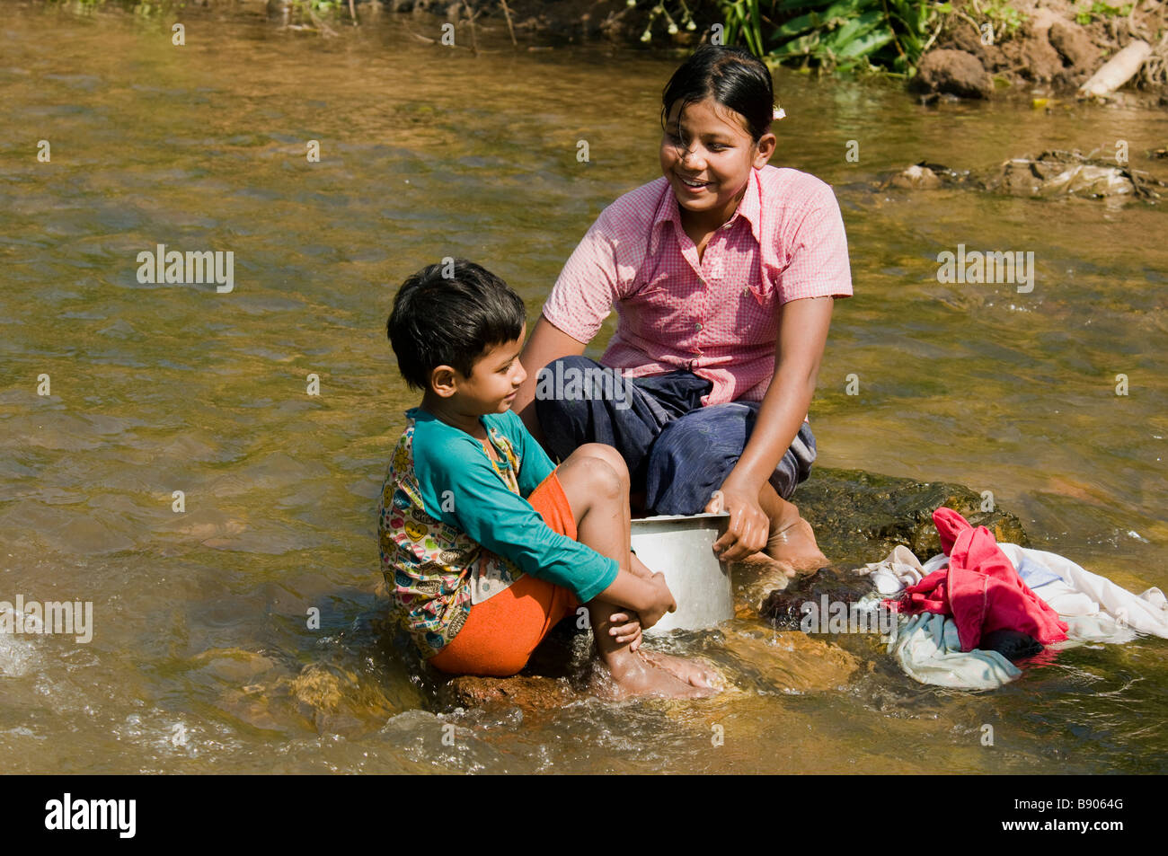 Refugee sorella e fratello a lavare i panni nel fiume nearMaela Refugee Camp,Tak,nel nord della Thailandia. Foto Stock