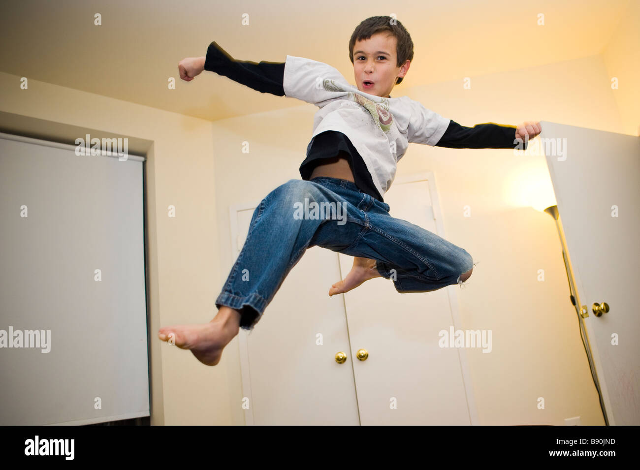 Un giovane ragazzo facendo un flying smash kick Foto Stock