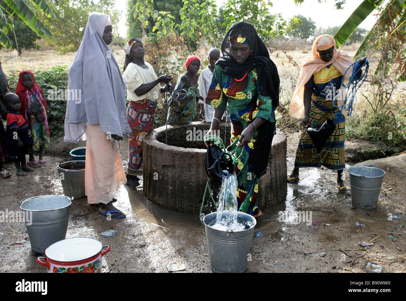 Nigeria: donna disegno acqua fresca da un pozzo Foto Stock