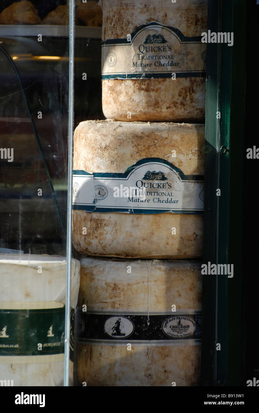 Turni di formaggi Chedder nella finestra di Deli in Rye in Sussex Foto Stock