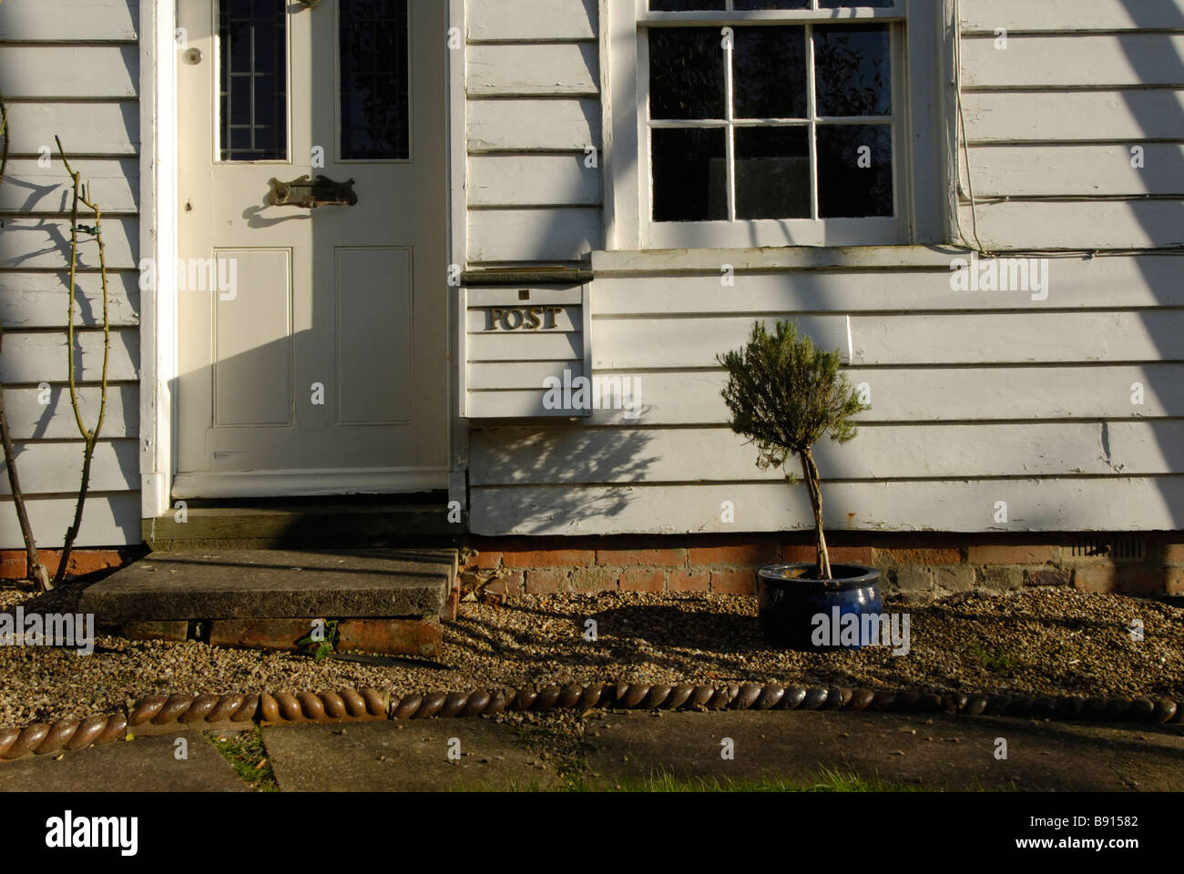 Vecchio bianco infissi in legno fronte casa ombre lunghe in battaglia East Sussex Foto Stock