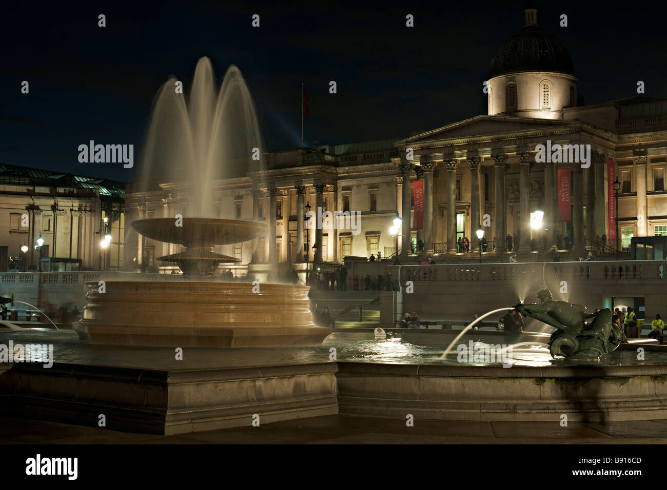 Trafalgar Square fontana Londra Inghilterra illuminata di notte la cucina nazionale è in background Foto Stock