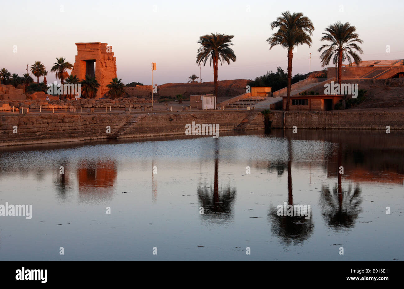 Tempio di Karnak al tramonto, palme riflessa nell'acqua del lago sacro, Luxor, Egitto, [Nord Africa] Foto Stock