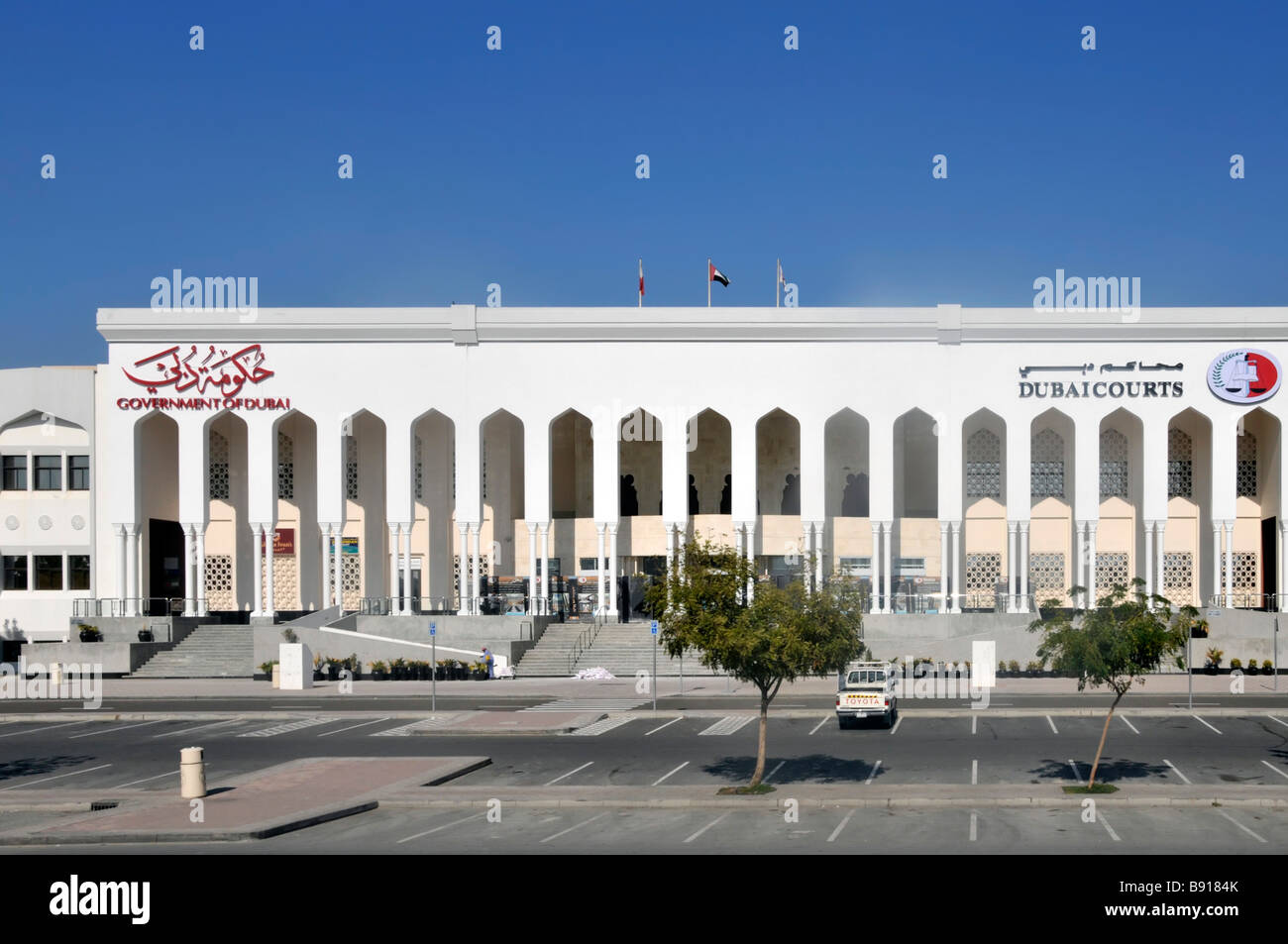 Parcheggio vuoto di Dubai il sabato presso il Law Courts & Uffici governativi edifici architettura bilingue segno e logo United Arab Emirati Arabi Uniti Medio Oriente Foto Stock