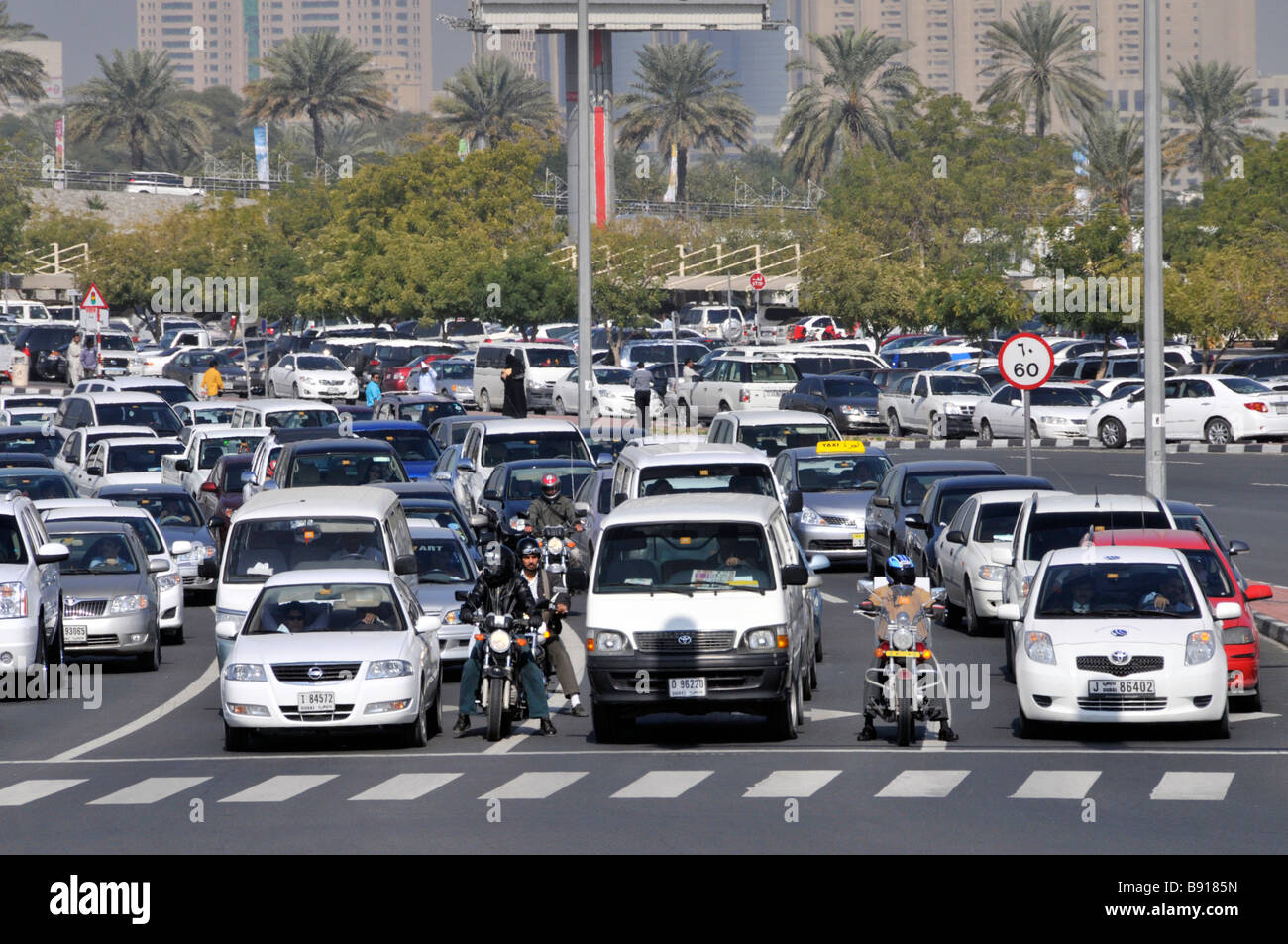 Dubai primo piano su strada trafficata e largo incrocio auto e moto In attesa al semaforo parcheggio di superficie oltre United Arab Emirati Arabi Uniti Medio Oriente Foto Stock