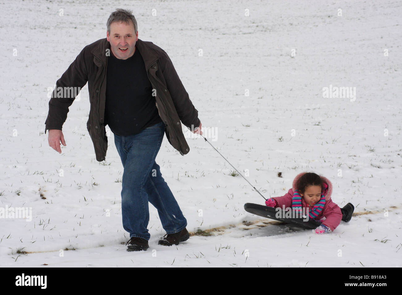 Figlia di padre bianco figlia toddlerl etnica nero razza mista sorridenti divertirsi giocando a snow ice giovani Foto Stock