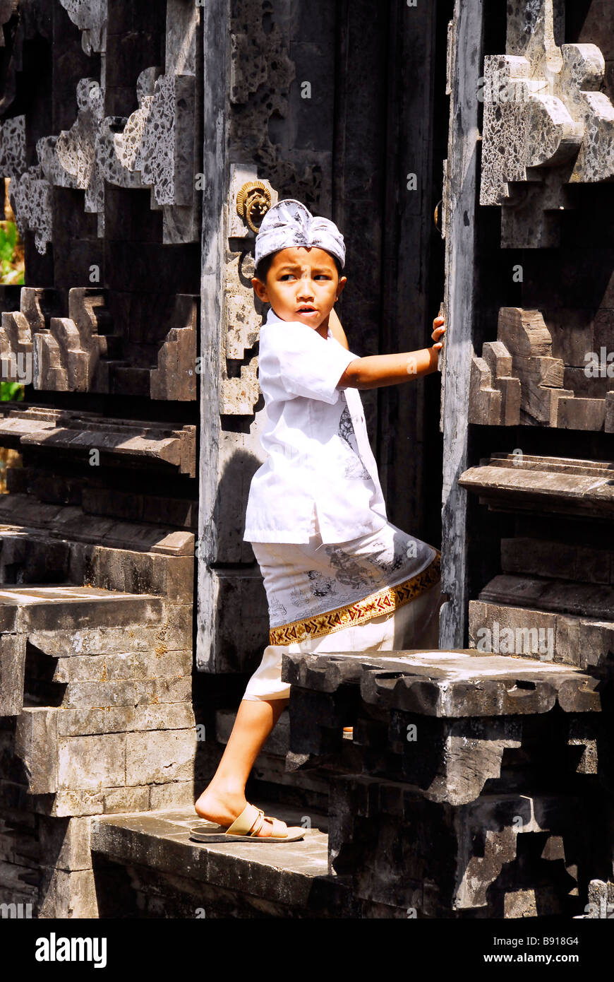 Ragazzo Balinese di entrare attraverso la porta del tempio,l'Indonesia. Foto Stock