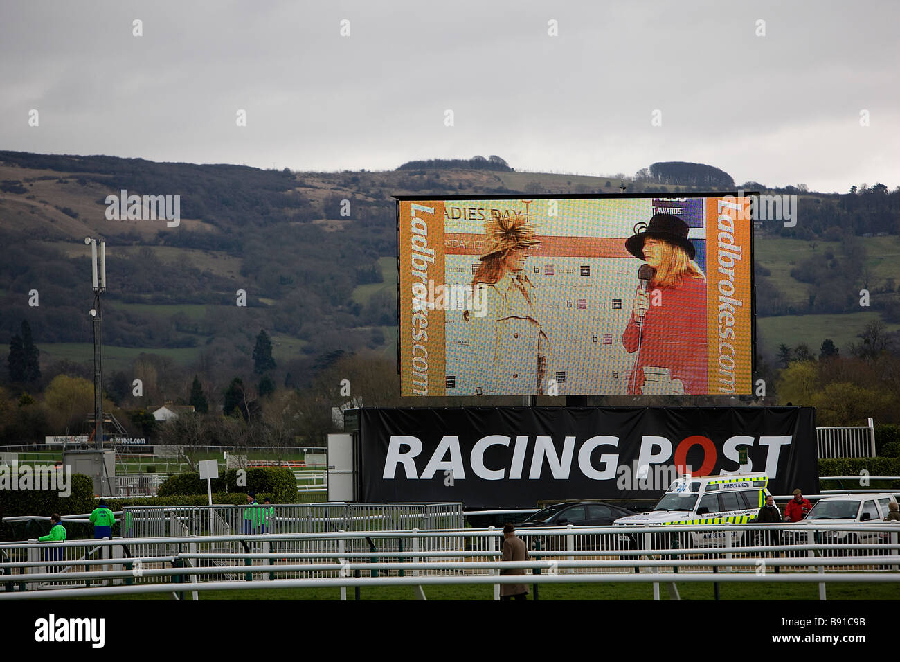 Lo schermo gigante sul Signore giorno al festival di Cheltenham che mostra un concorrente di moda prima l'inizio delle corse Foto Stock