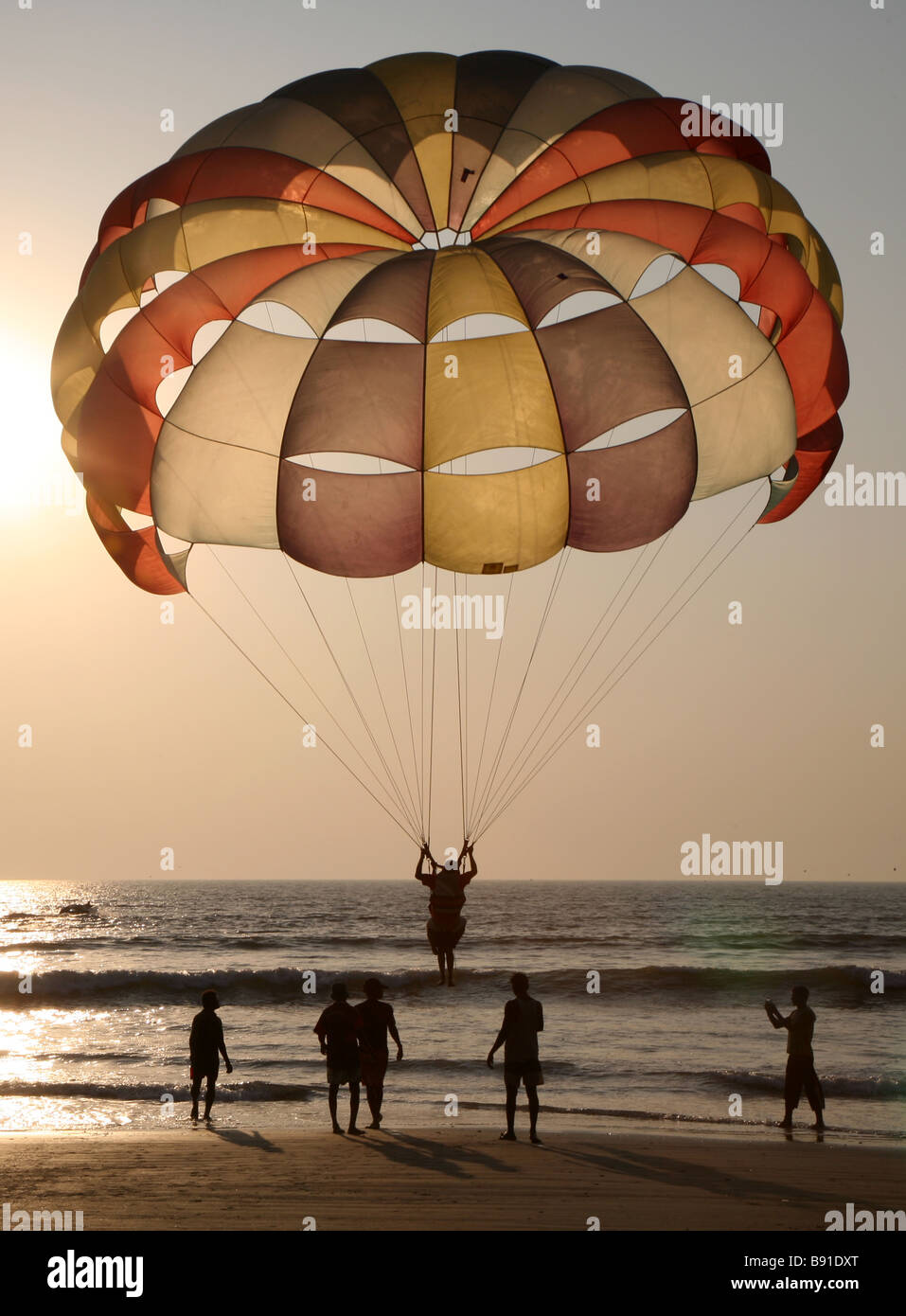 Un parapendio decolla dalla spiaggia di Mobor in Goa, India. Foto Stock