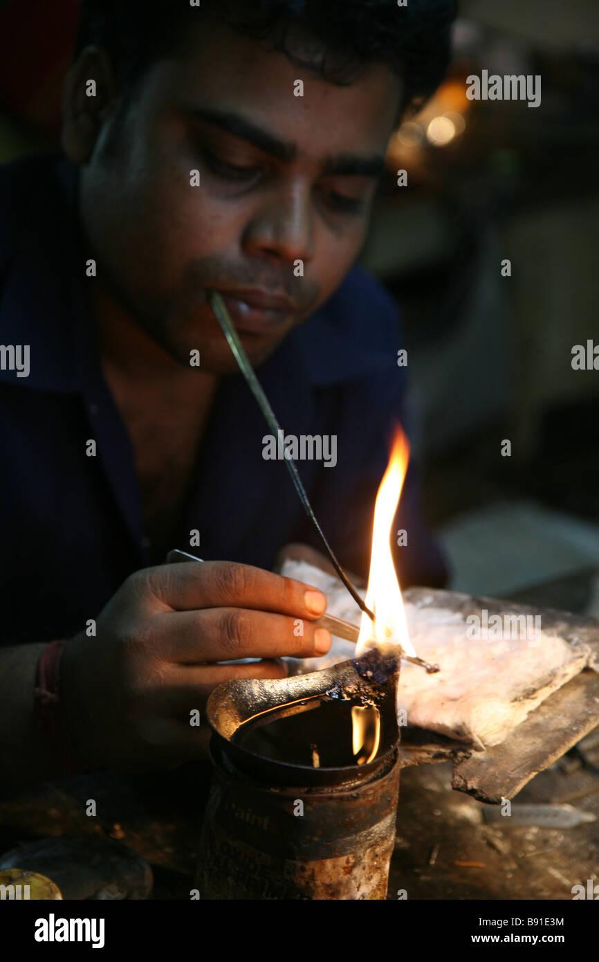 Gli uomini locali creazione di gioielli in una piccola officina per la vendita nel mercato vicino a Mobor in Goa, India Foto Stock
