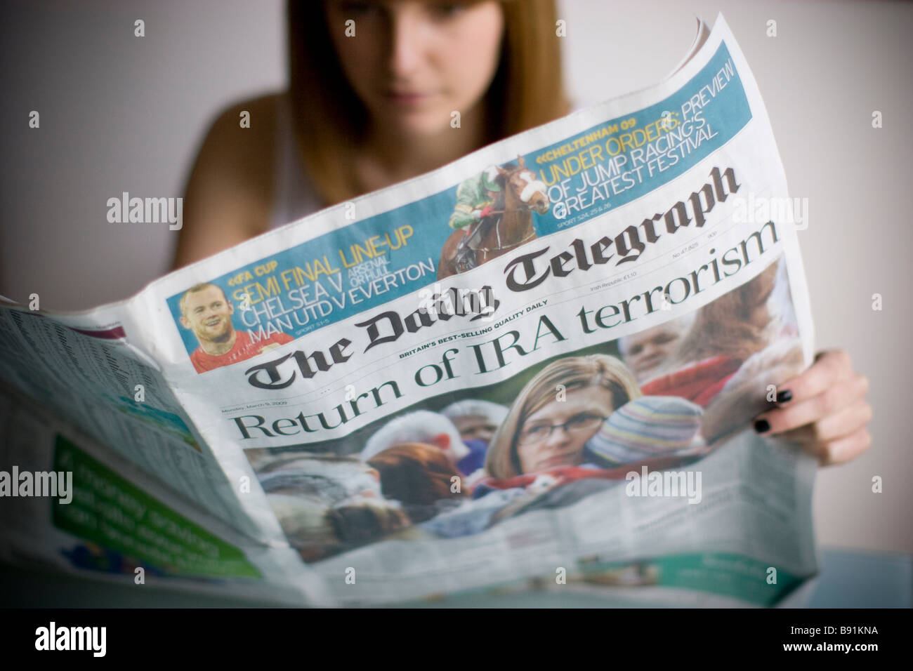 Giovani femmine leggendo il quotidiano Daily Telegraph con ira il terrorismo headline Foto Stock