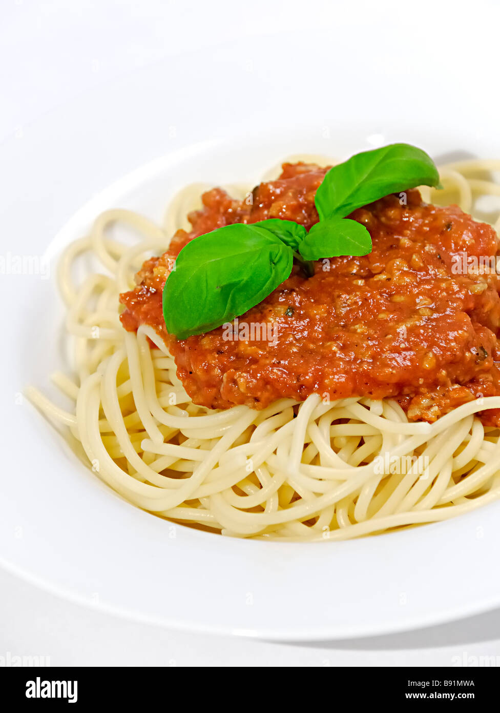 Spaghetti bolognese con basilico fresco Foto Stock