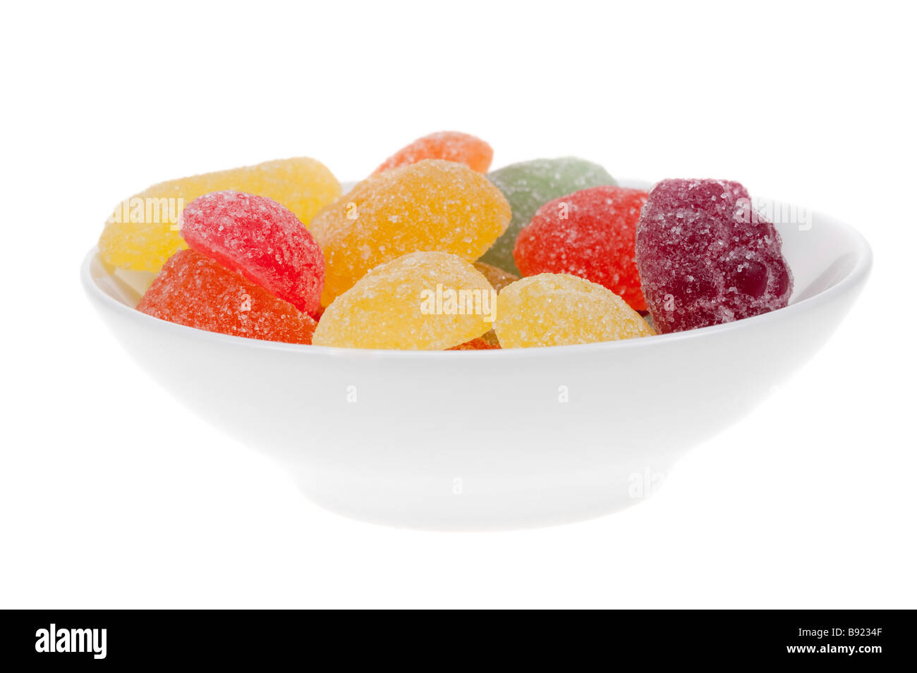 Ciotola di caramella di frutta in molti colori isolati su sfondo bianco Foto Stock