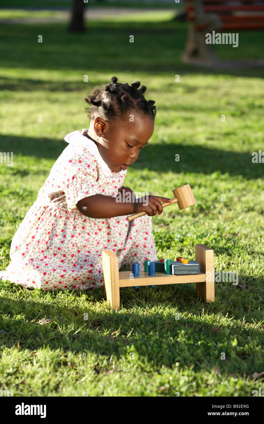 Figlia giocando sull'erba con il suo giocattolo di legno Parco Dewaal Cape Town Western Cape Province Sud Africa Foto Stock