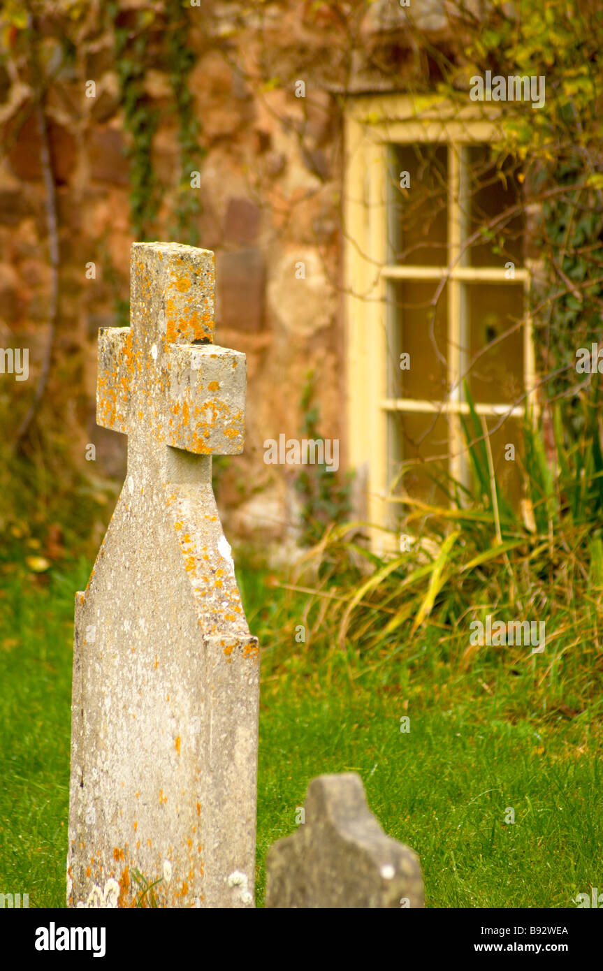 Croce di granito e vicarage finestra dettaglio in Dunster sagrato Exmoor Somerset REGNO UNITO Foto Stock