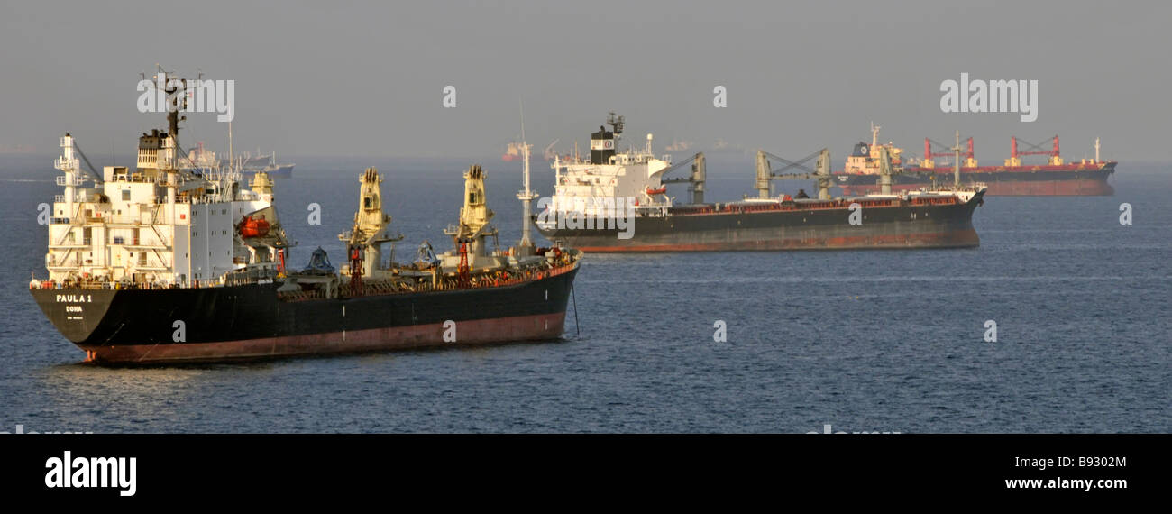 Spedizioni in calore haze comprese le navi portarinfuse & petroliere in mare l'ancoraggio fuori costa di Fujairah Golfo di Oman vicino a stretto di Hormuz in Medio Oriente Foto Stock