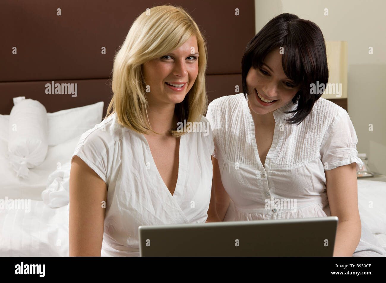 Frauen sitzen am Bett und surfen mit Laptop im internet Foto Stock