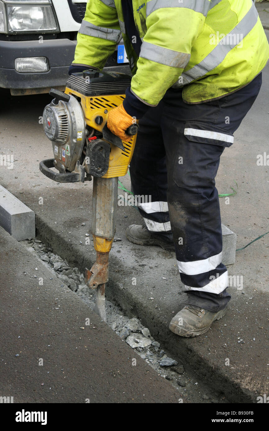Lavoratori stradali, costruiscono, mantengono, migliorano, riparano strade, lavoro, gruppo specializzato, responsabilità, pneumatico, trapano, martelletto, bitume, asfalto. Foto Stock