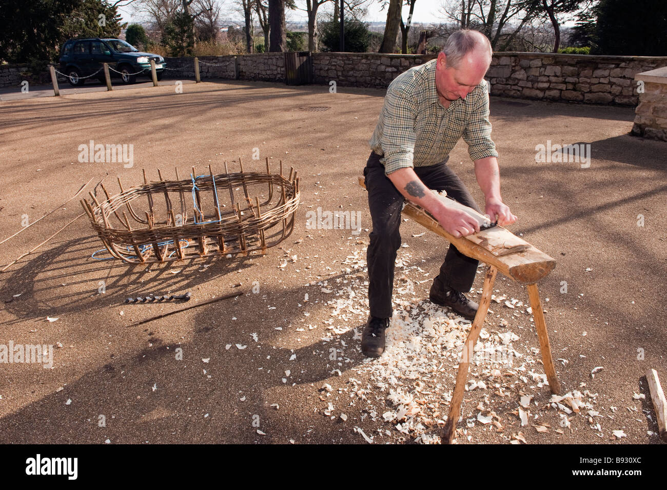 Coracle maker spianare un tratto piano di legname Foto Stock