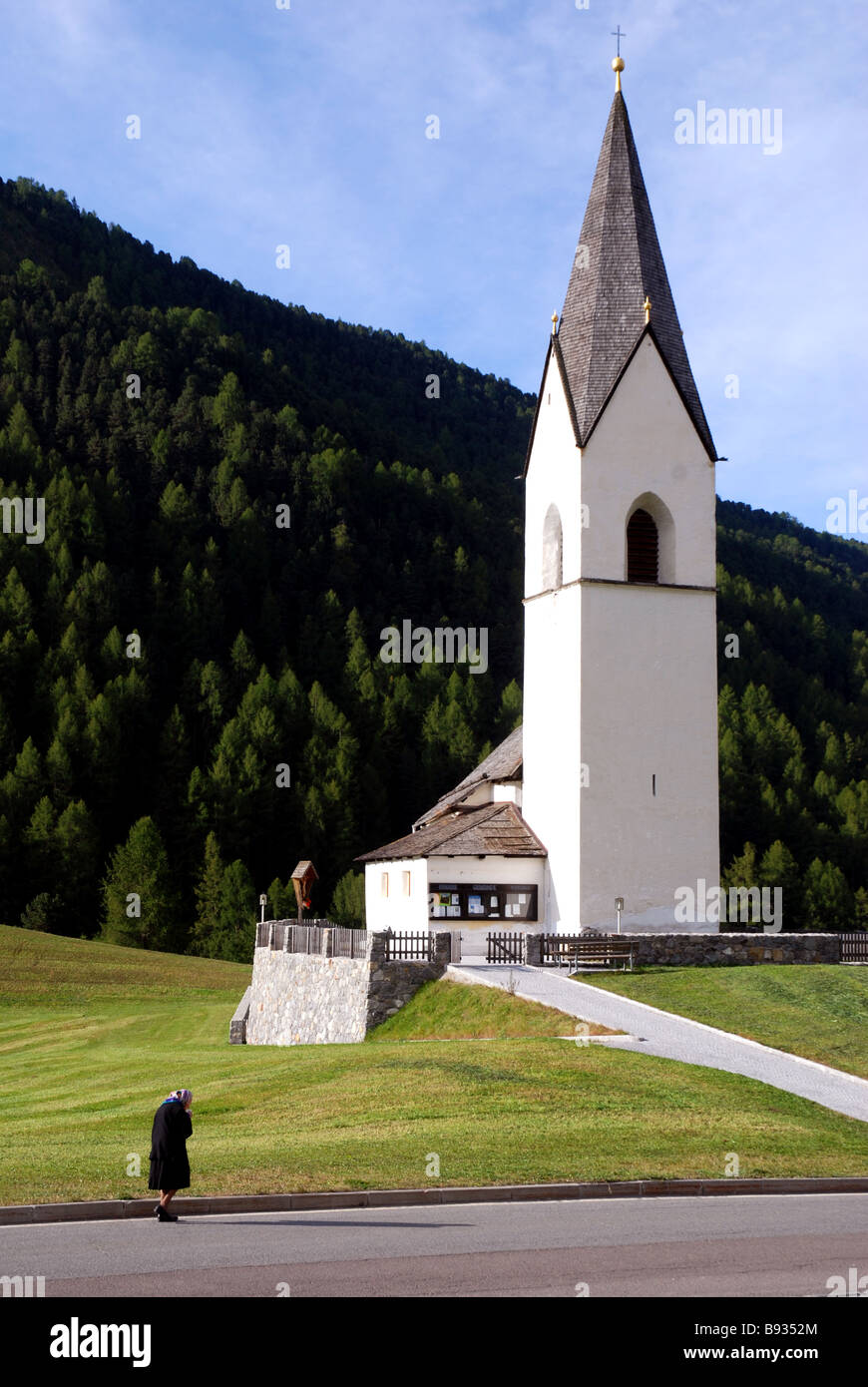 Donna vecchia a piedi chiesa Lantauferntal Langtaufern valley Sout Alpi tirolesi Alti Adige Italia Foto Stock