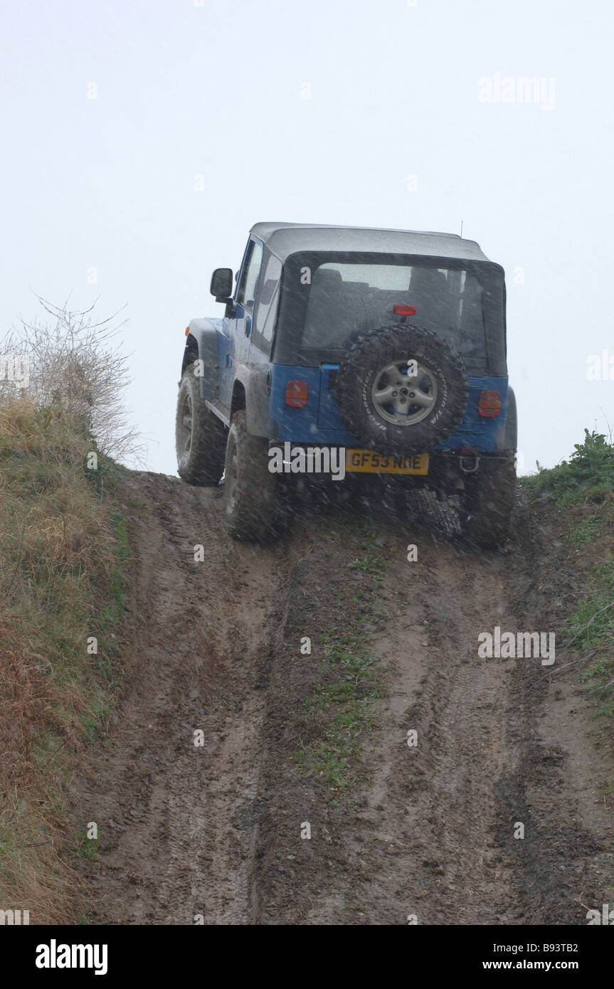 Jeep Wrangler 4x4 creste collina ripida traccia di fango nella neve Foto Stock