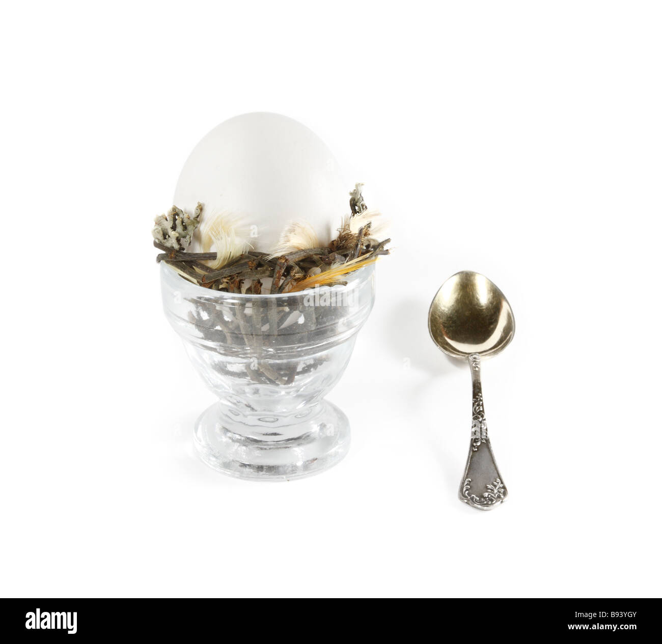 Uovo in vetro e cucchiaino su sfondo bianco Foto Stock
