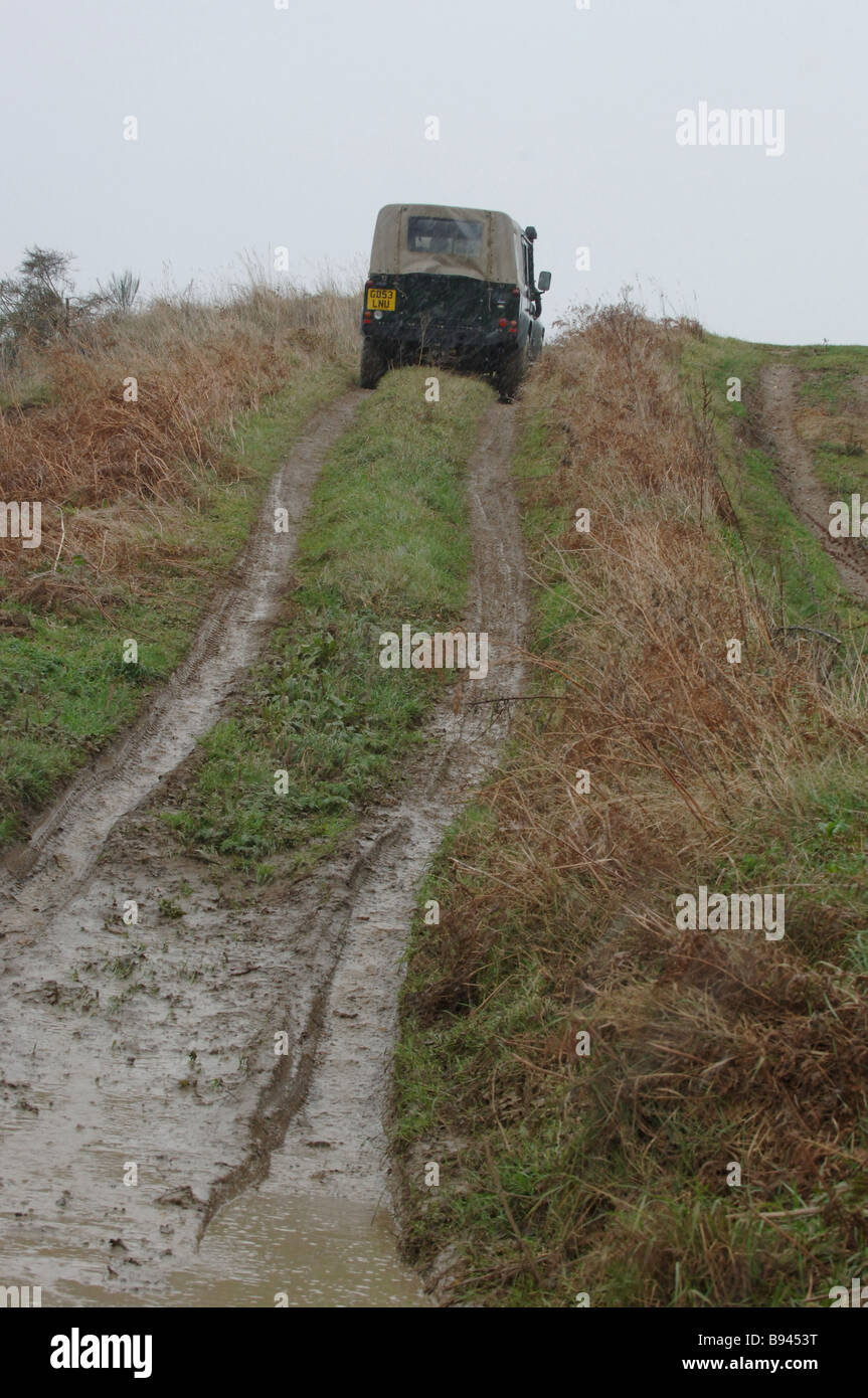 Land Rover Defender sulla traccia di fango nel paese Foto Stock