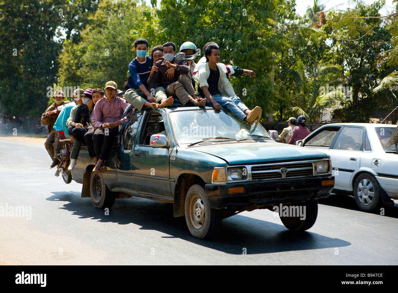 Gli uomini e le motociclette pack su un carrello a cavallo lungo la strada che da Phnom Penh di Kompong Chhang Foto Stock