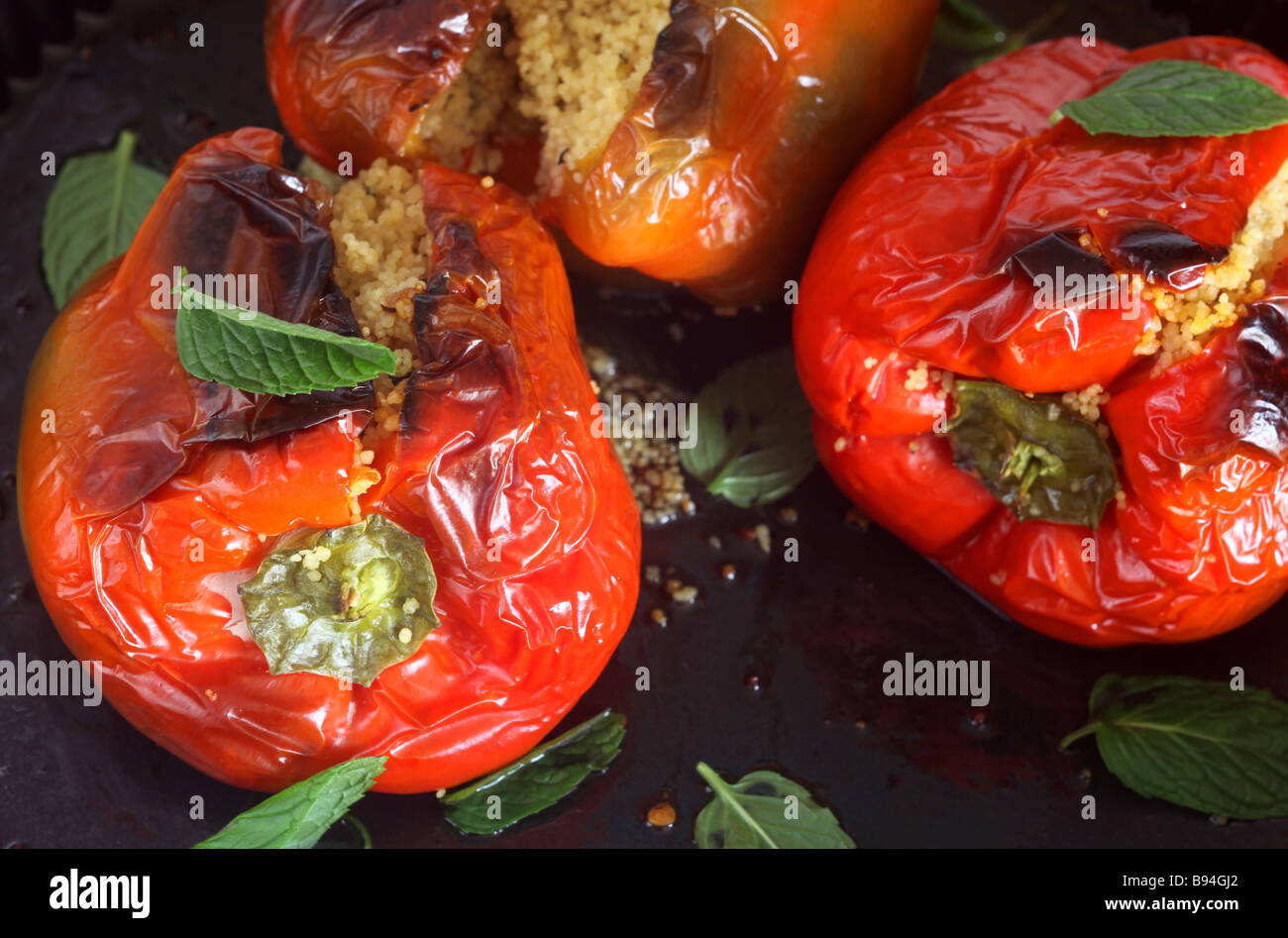 Un tradizionale del Nord Africa Medio Oriente pasto vegetariano di peperoni cotti al forno ripiene di cous cous, menta e uvetta Foto Stock