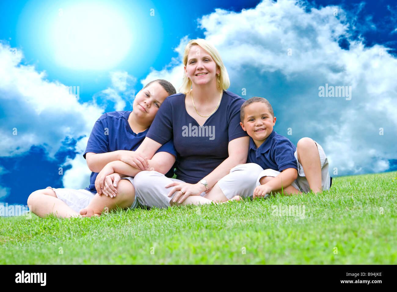 Piuttosto la mamma con i suoi due figli al di fuori di erba Foto Stock