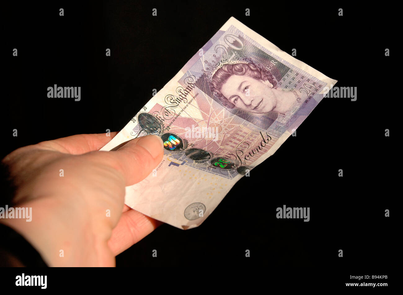 Una mano che tiene una ventina di pound nota. Foto Stock