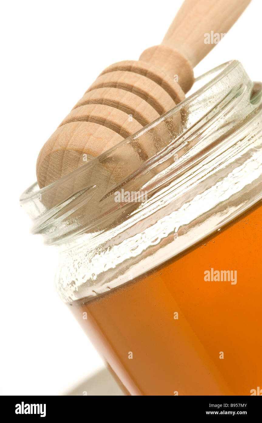 Vasetto di miele e cucchiaia di legno Chiudi Foto Stock