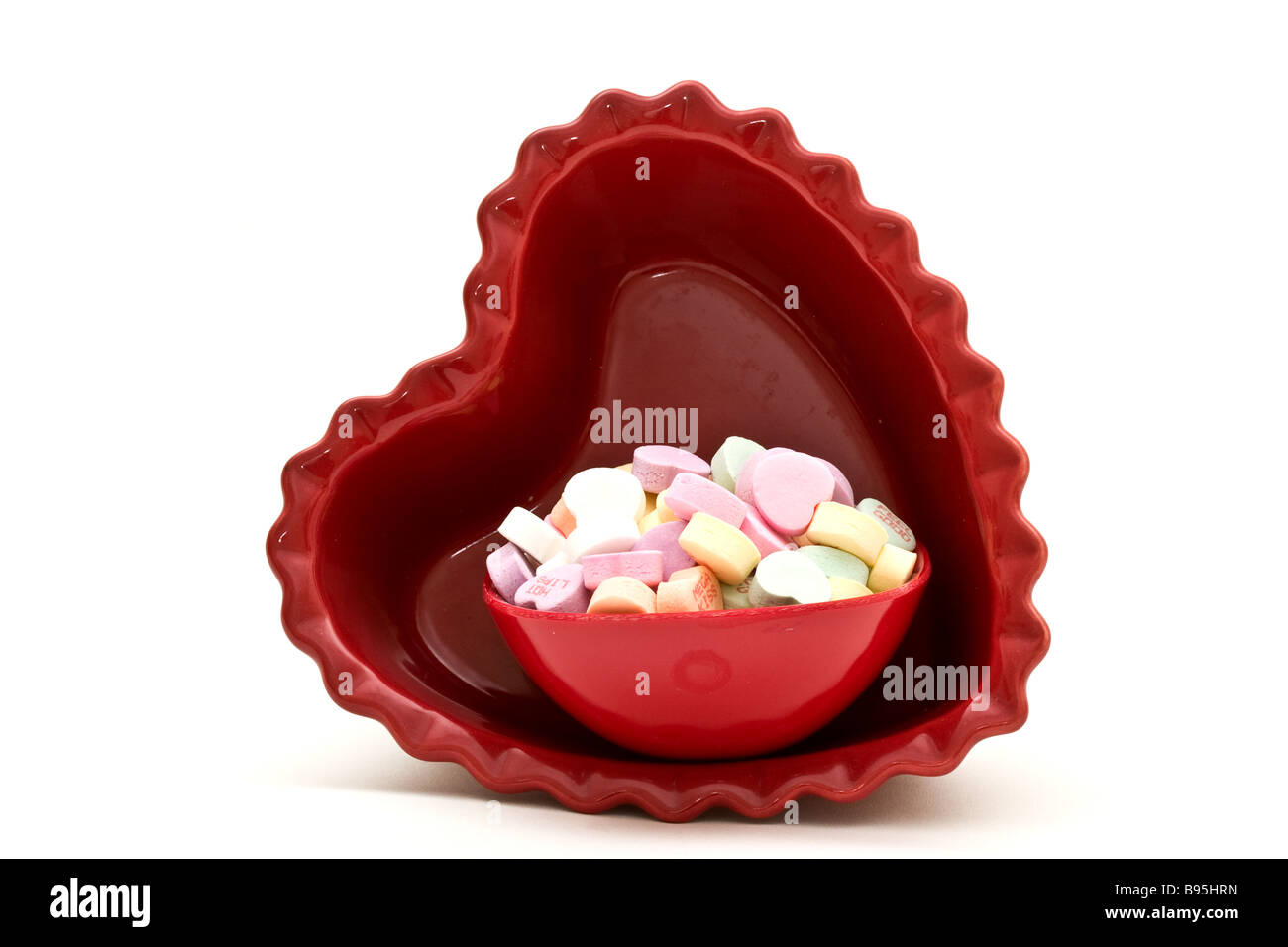 Piccolo piatto candy riempito con a forma di cuore ad candy all'interno di un più grande a forma di cuore piatto di caramelle Foto Stock