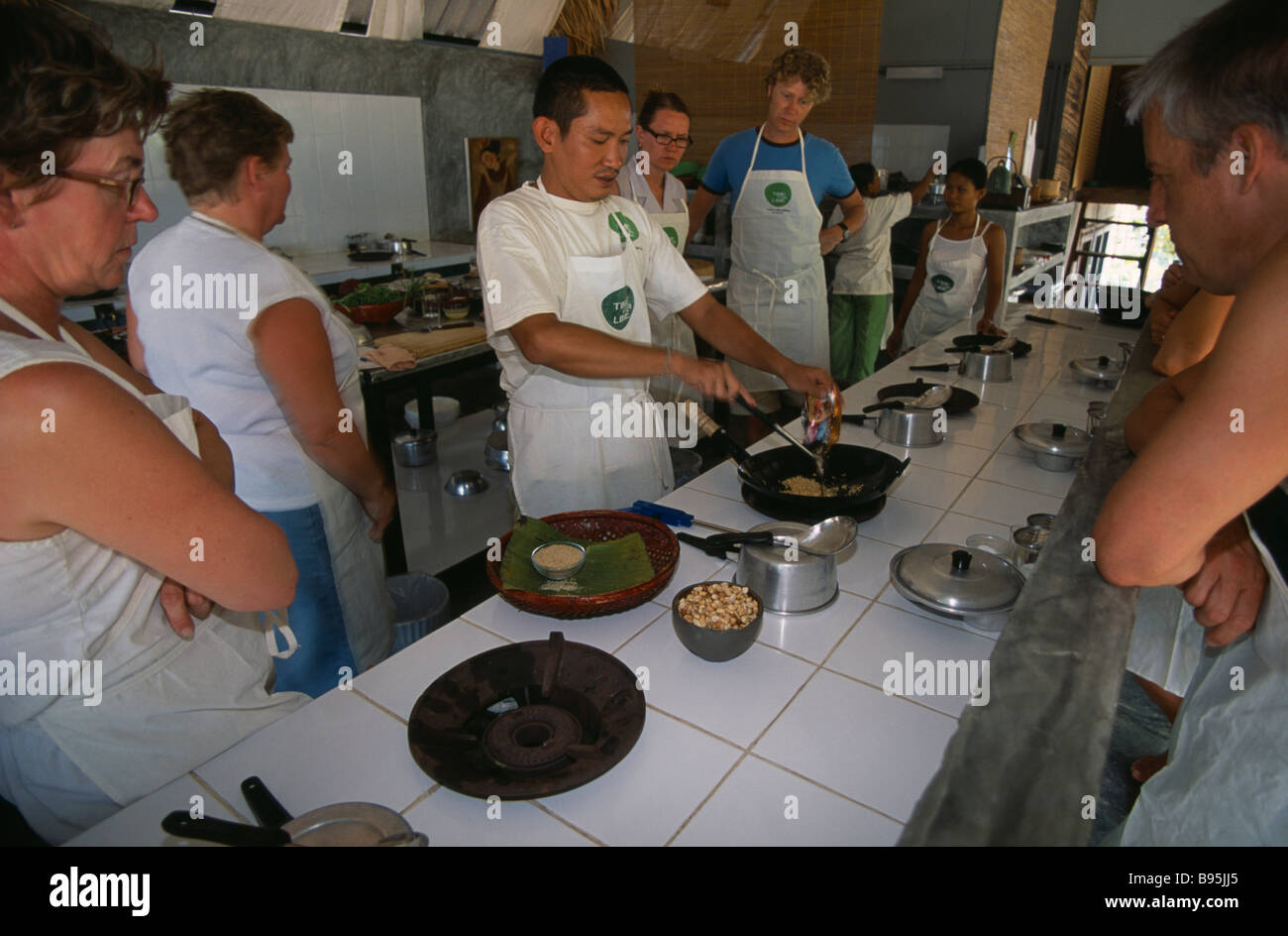 Tailandia Krabi Koh Lanta Yai Cookery il tempo in classe per la calce sulla spiaggia di Klong dao istruttore chef cucinare con i turisti utilizzando wok Foto Stock