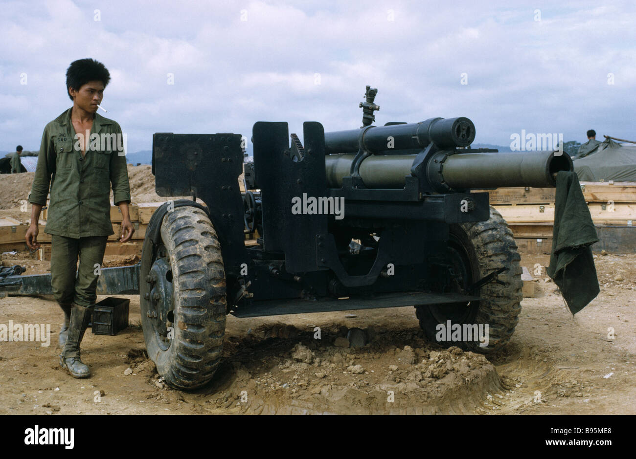 Guerra del Vietnam Highlands Centrali assedio di Kontum Montagnard hill tribe soldato accanto a un obice cannone di artiglieria Foto Stock