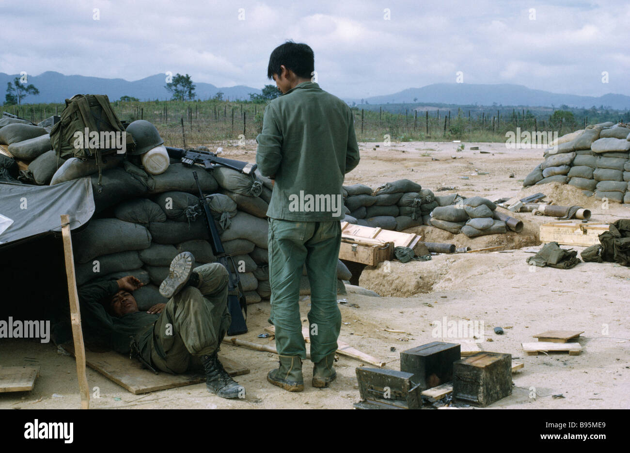 Guerra del Vietnam Highlands Centrali assedio di Kontum Montagnard tribù della collina i soldati in camp con sacchi di sabbia e rifugi di fortuna Foto Stock