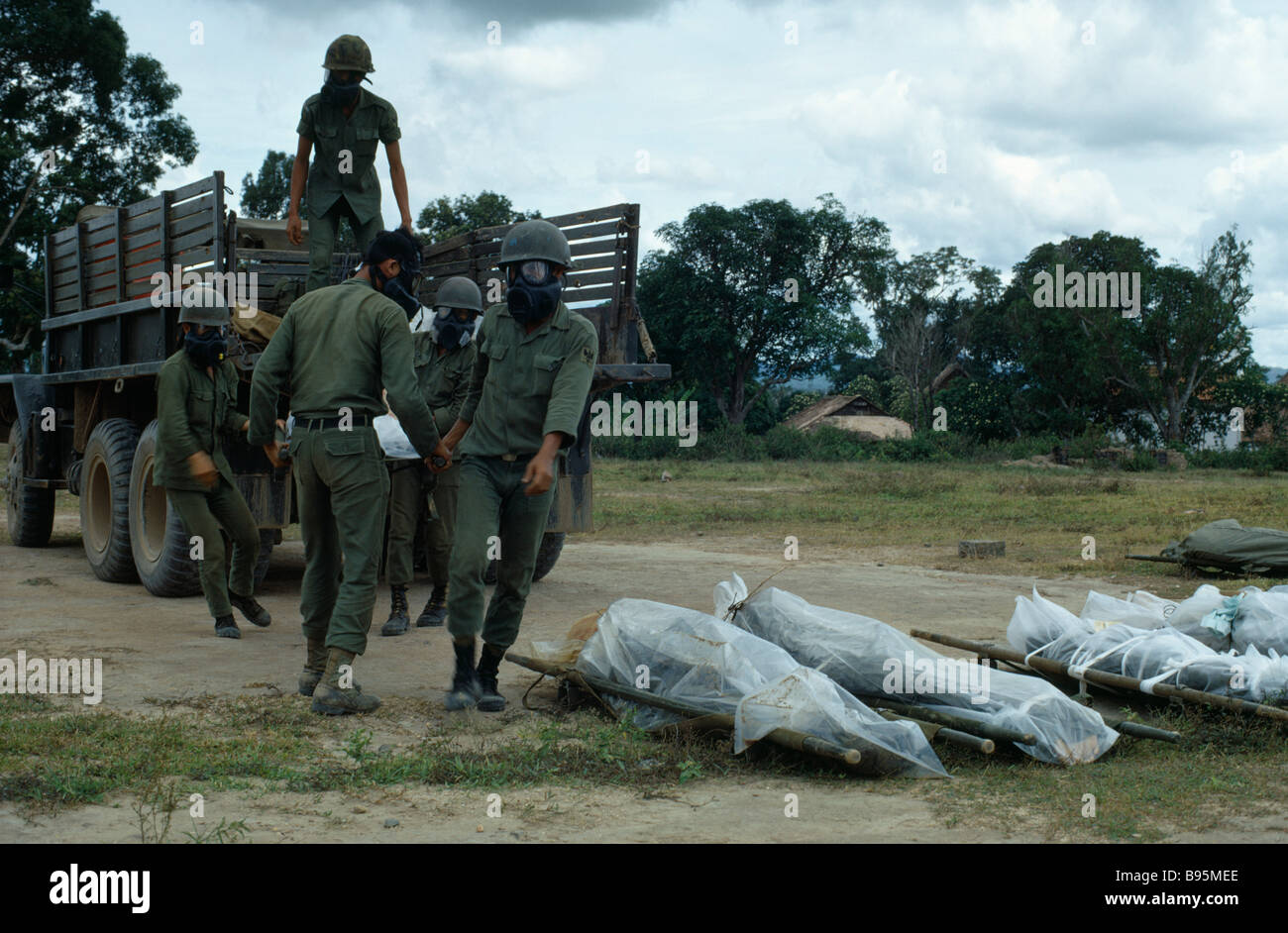 Guerra del Vietnam Highlands Centrali assedio di Kontum Montagnard soldati indossano maschere di gas di scarico di cadaveri avvolti in plastica Foto Stock