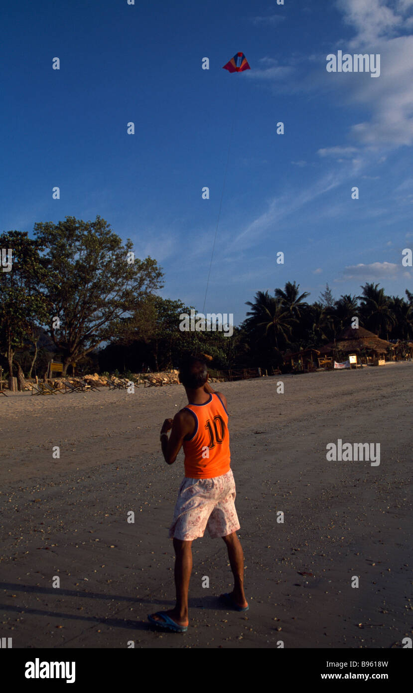 Tailandia Krabi Koh Lanta Yai sulla spiaggia di Klong dao con un uomo sulla sabbia volare un aquilone nel cielo. Foto Stock
