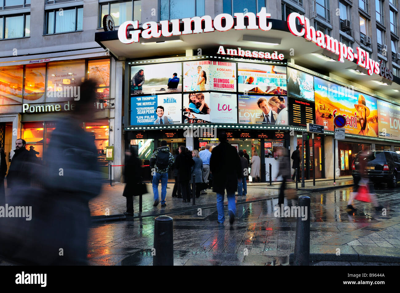 Parigi Champs Elysees occupato, Francia, Busy Street Scene Cinema Theatre, illuminato, pioggia, crepuscolo Cinema Teatro poster Marquee, in attesa fuori francese Foto Stock