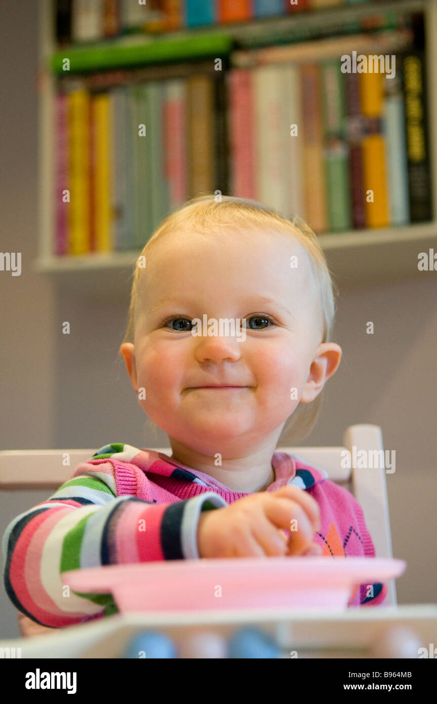 Ragazza sorridente bambino 14 MESI IN UNA SEDIA ALTA IN UNA CUCINA Foto  stock - Alamy