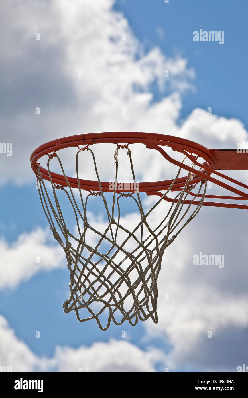 Basketball hoop e net contro il bianco delle nuvole in cielo blu Foto Stock