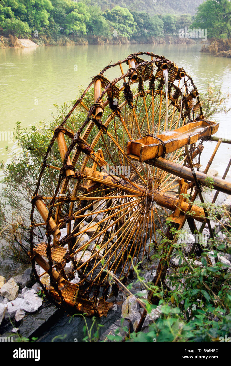 Bambù antica ruota di acqua sulla pesca Blossum fiume vicino a Guilin utilizzato dagli agricoltori per irrigazione Foto Stock