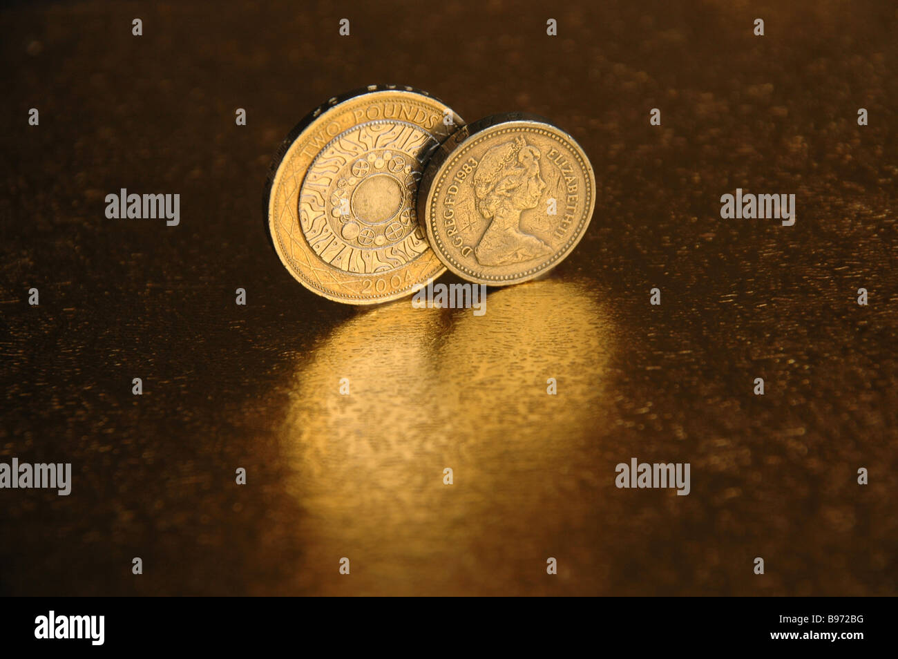 Un uno e due libbre di monete e la loro riflessione. Foto Stock
