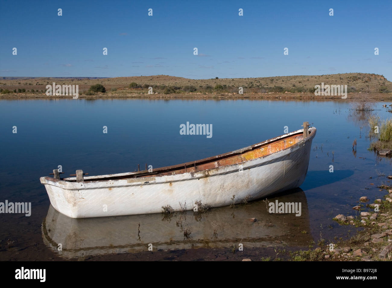 Un apparentemente deserta barca siede su un laghetto di irrigazione nel mezzo di un paesaggio secco nel Sud Africa Capo Settentrionale Foto Stock