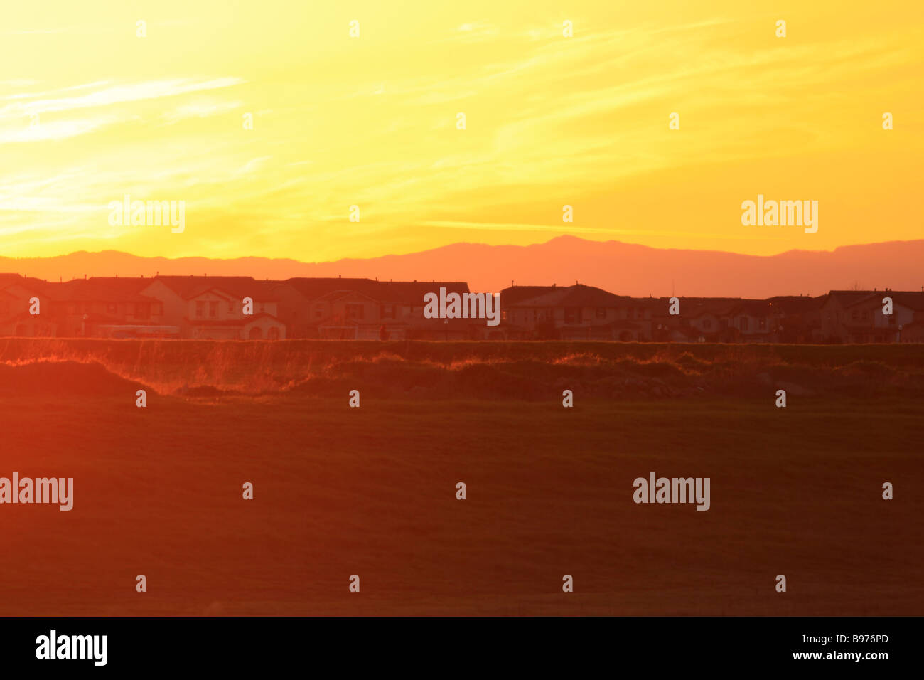 Tramonto nella California settentrionale campo agricolo essendo encraoche dalla rapida alloggiamento suburbana di sviluppo. Foto Stock