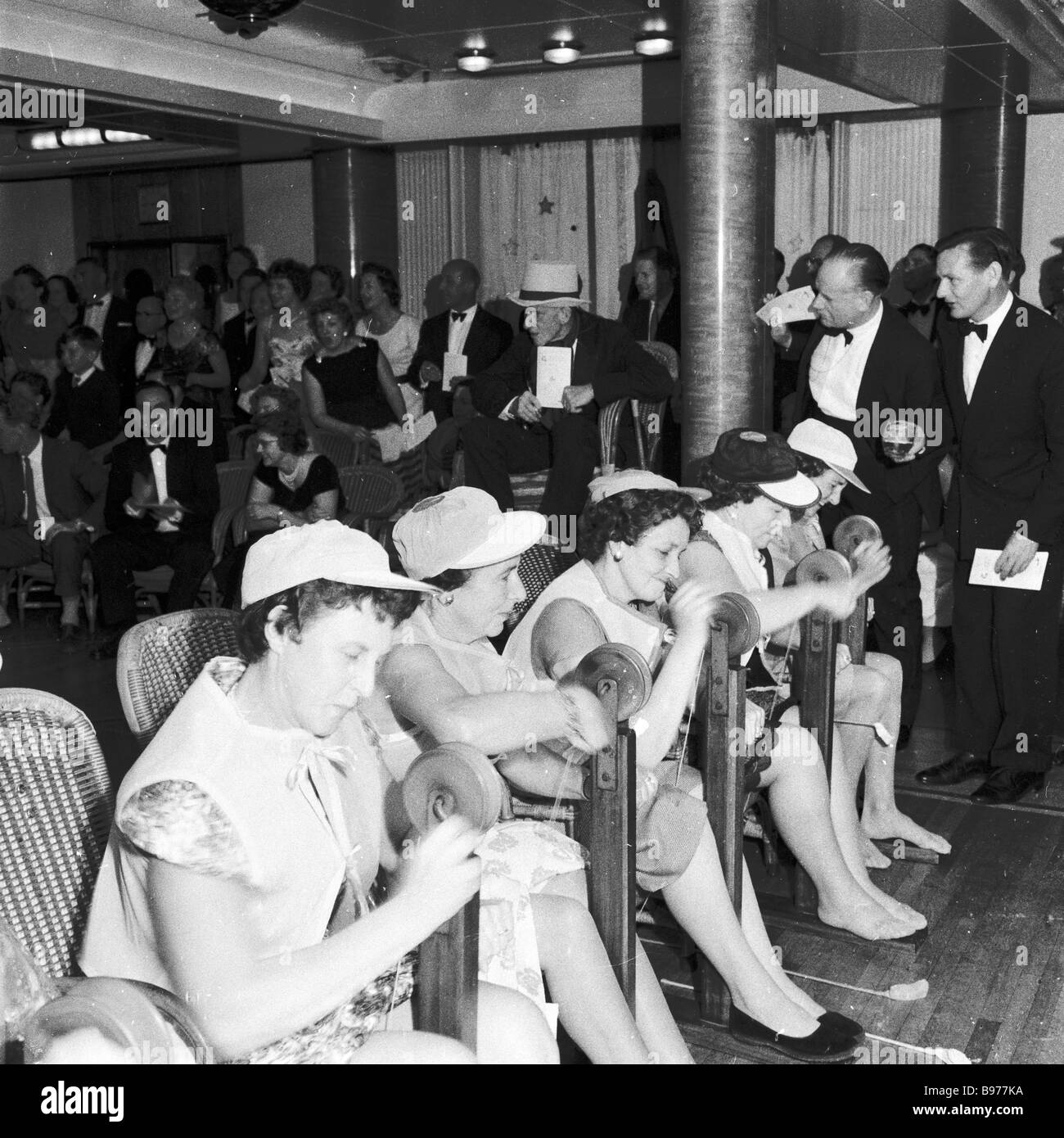 1950s, sera tempo & donne crociera passeggeri a bordo di un vascello della British India Steam Navigation Co divertirsi giocando un gioco di corse ippiche. Foto Stock