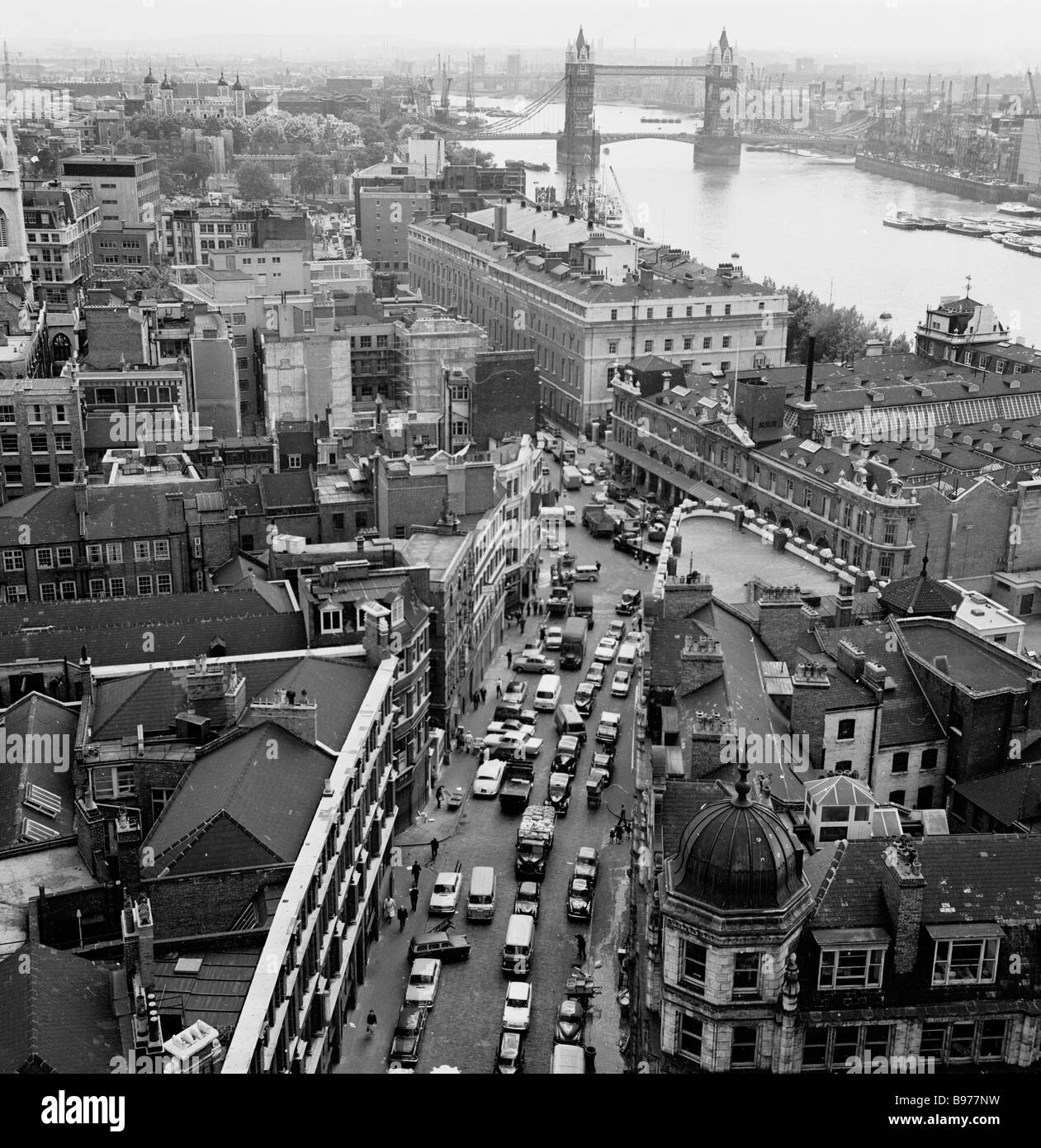 1960s, storico, una vista aerea sulla città di Londra, con Tower Bridge in lontananza. Primo piano, il famoso mercato del pesce di Billingsgate. Foto Stock