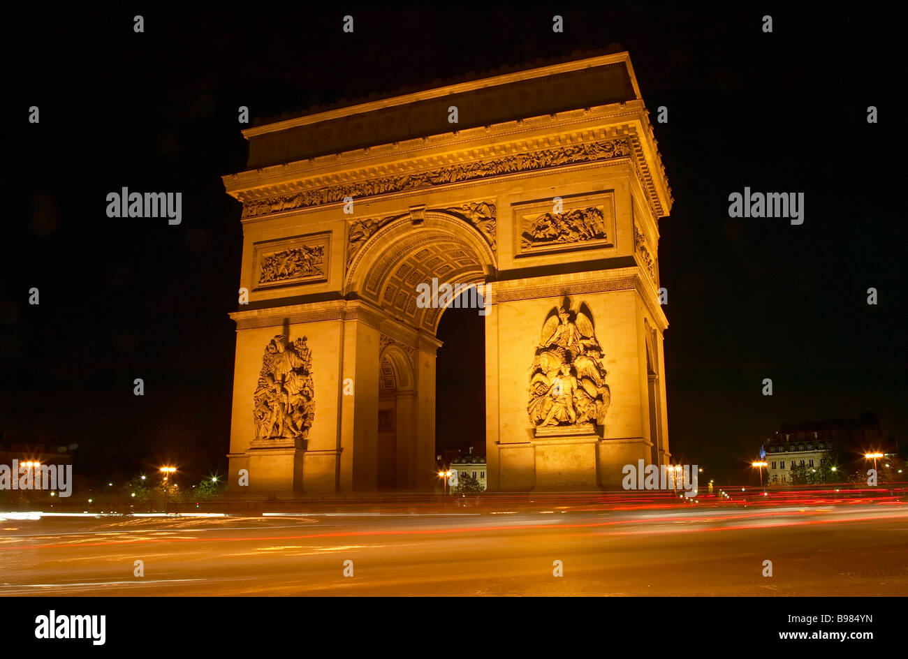 Il traffico crea percorsi di luce sulla Place Charles de Gaulle intorno all'Arc de Triomphe a Parigi di notte, Francia. Foto Stock
