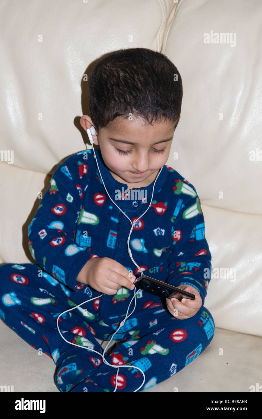 Little Boy ascoltando musica su ipod nano Foto Stock