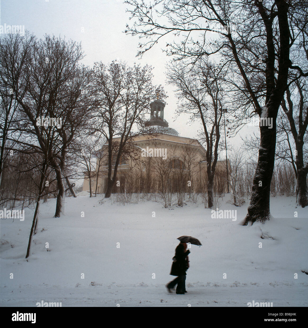 Coppia con ombrello in neve nella parte anteriore della Chiesa Skeppensholmen, Stoccolma, Svezia Foto Stock